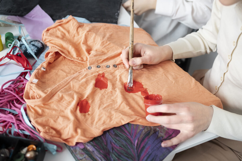 Pessoa transformando uma camisa com pinturas.