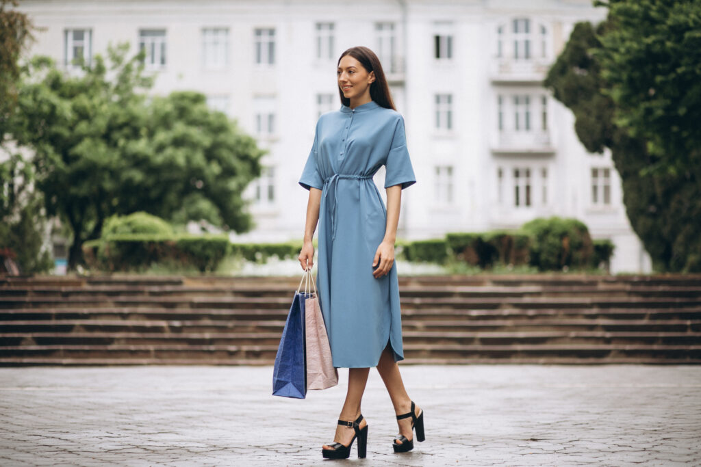 Mulher usando vestido vintage azul em ambiente urbano.