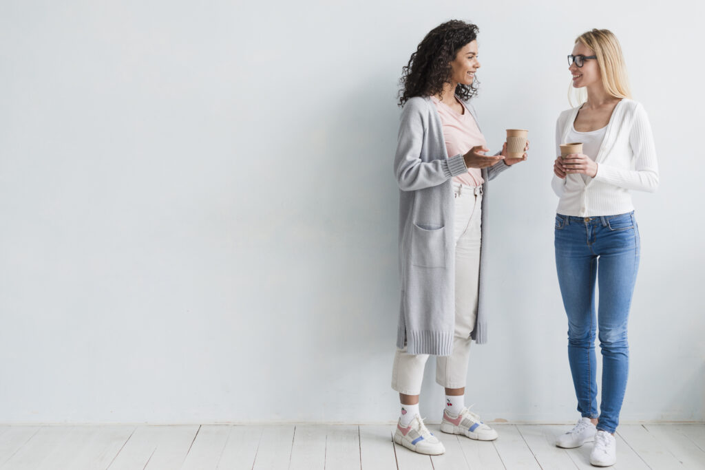 Duas pessoas usando looks minimalistas com tons neutros e sobreposições leves.