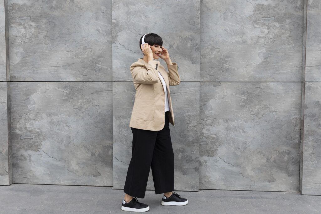 Mulher usando blazer vintage com calça larga e tênis moderno.