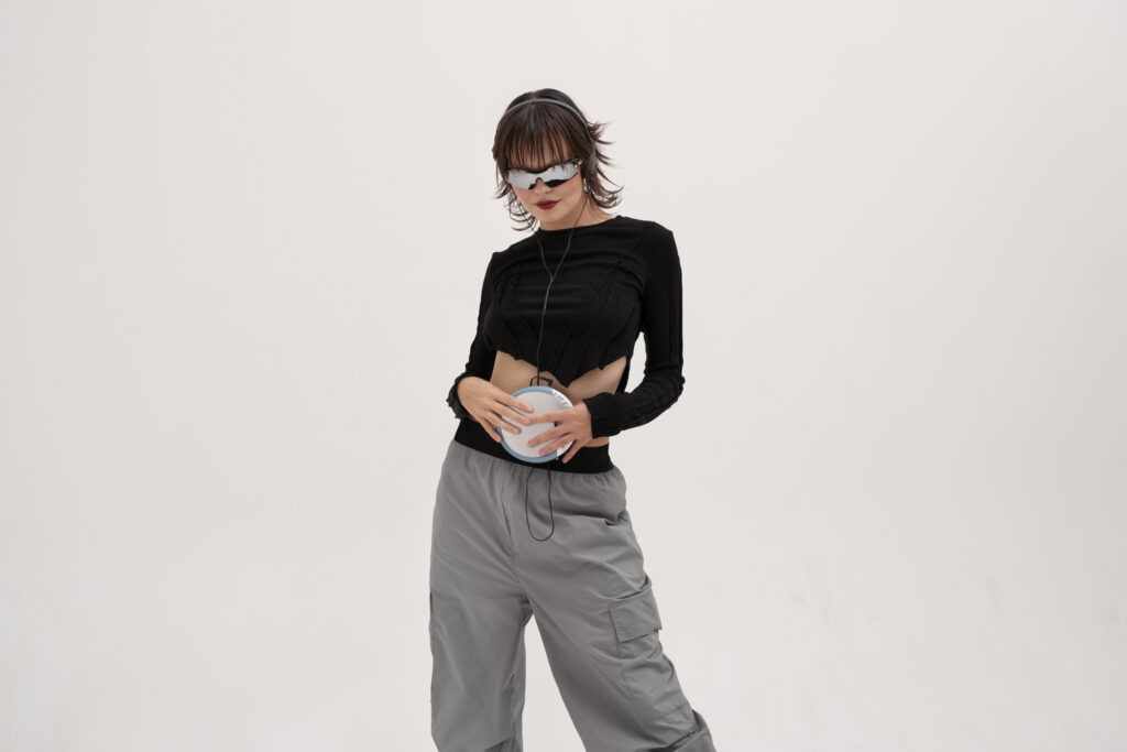 Mulher usando cropped preto e calça cargo cinza.