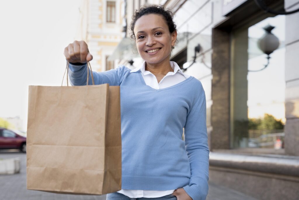 Pessoa segurando sacola de compras reutilizável em brechó de bairro